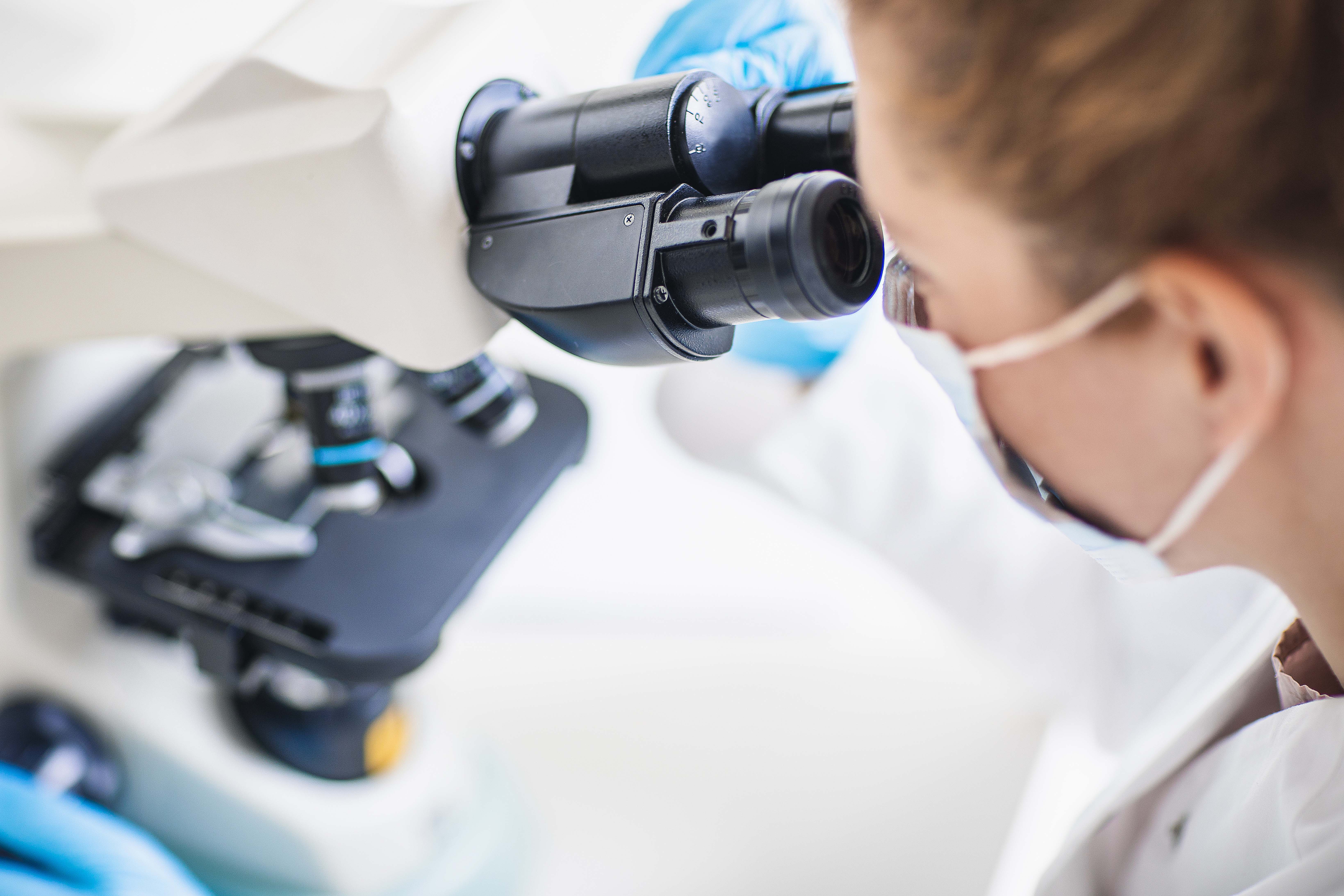 Histologist looking through a microscope